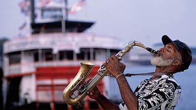 Older person with a beard playing a saxaphone