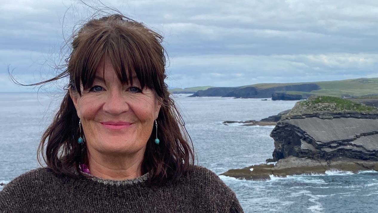 Siobhan Daniels in front of a craggy coastline