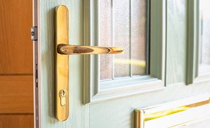 Shallow focus of an ornate, high security door handle and lock seen on a newly installed composite double glazed door