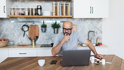 Mature adult man consulting with doctor using laptop