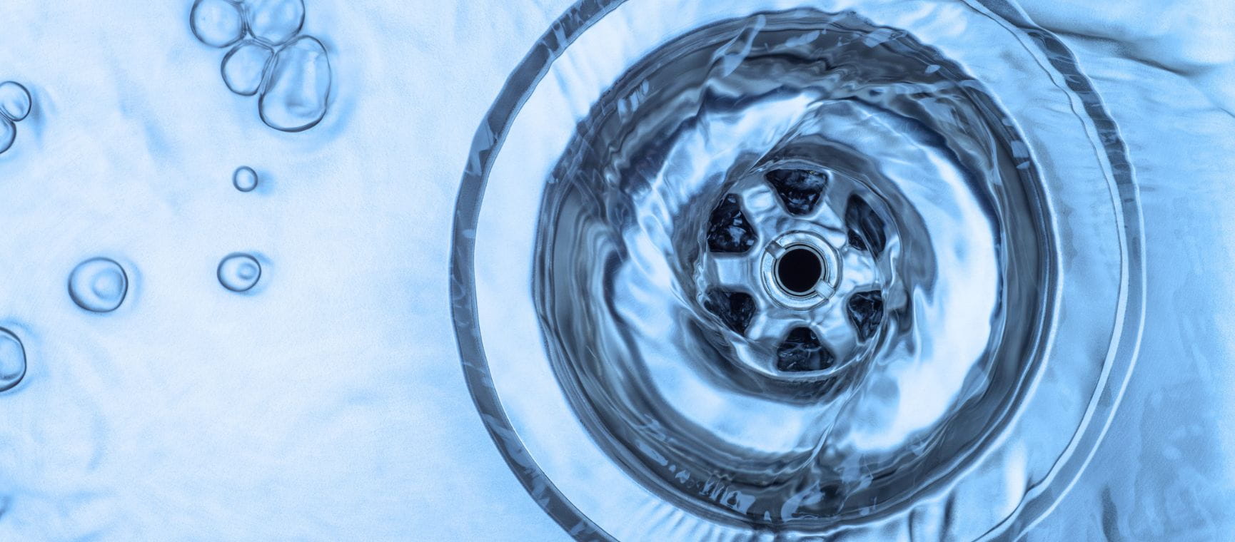 A close up of a plug hole in a stainless steel sink