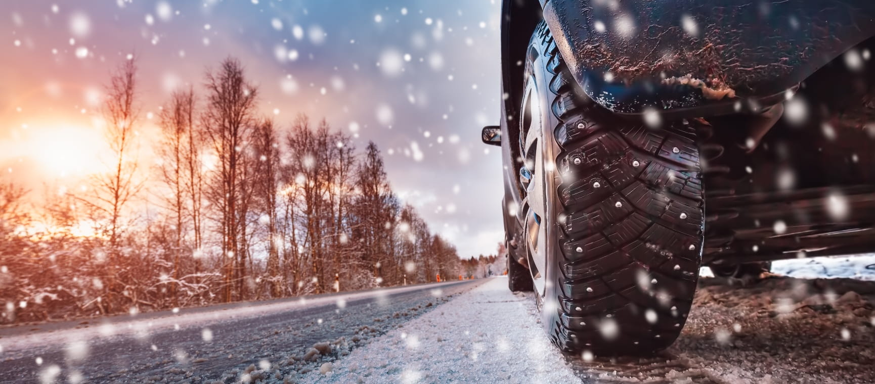 Driving along a tree-lined road on a snowy day