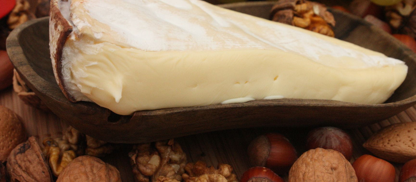 A piece of Vacherin Mont d'or cheese surrounded by nuts