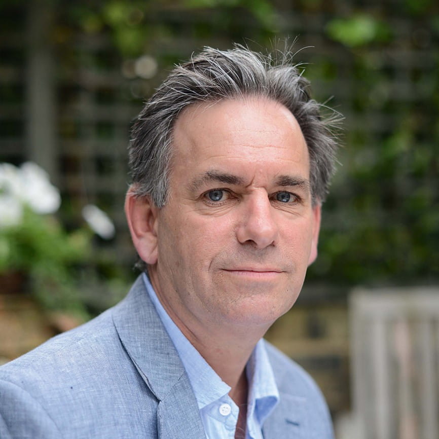 A headshot of Mark Palmer smiling at the camera