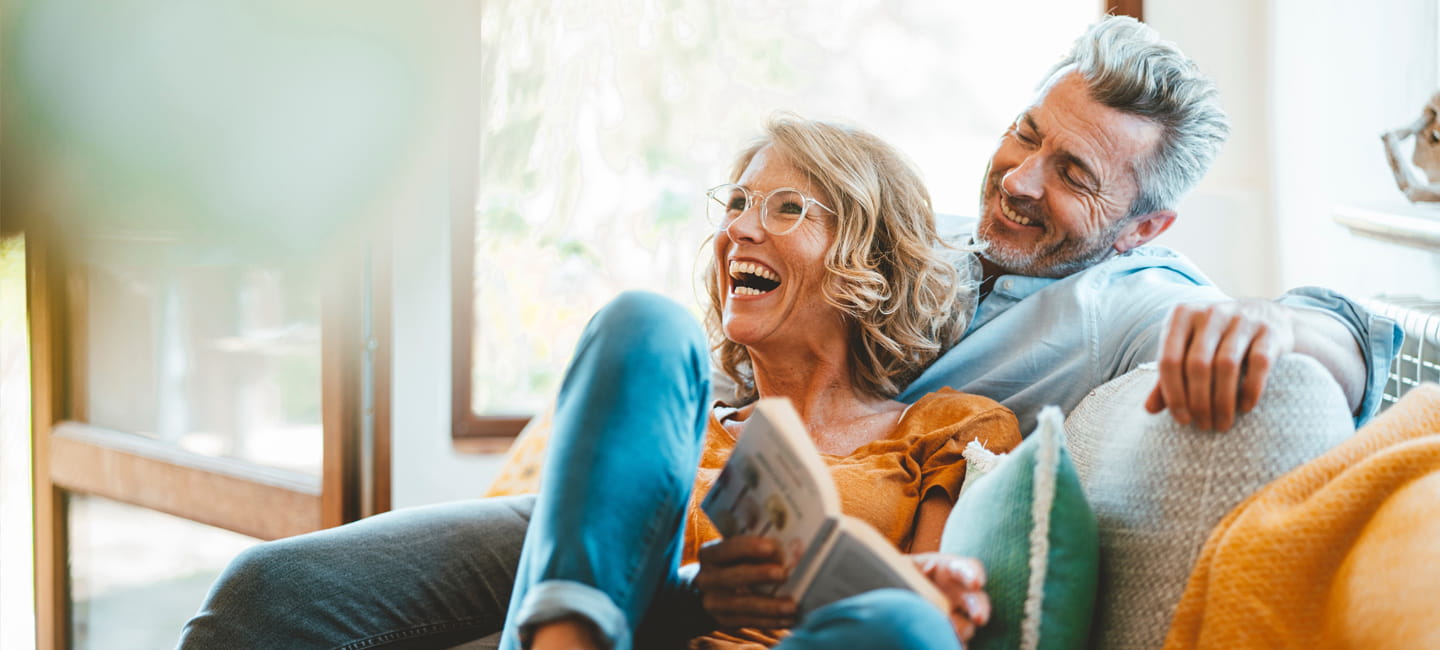 Two people on a sofa laughing