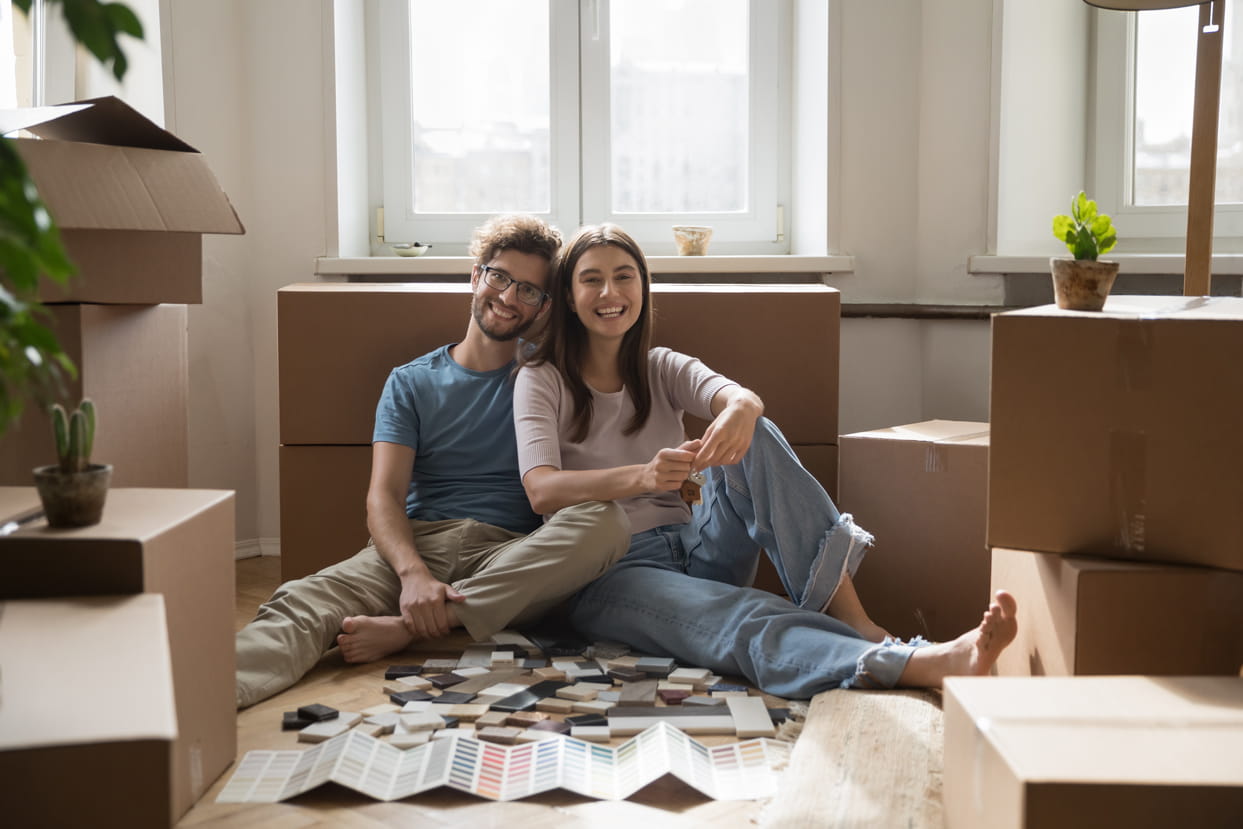 A younger couple sat in a new home looking at decorating colour schemes