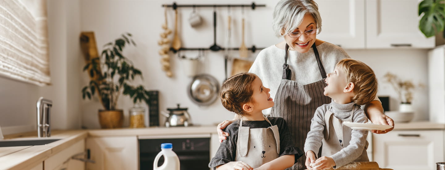 A grandmother with her grandchildren at home in the kitchen