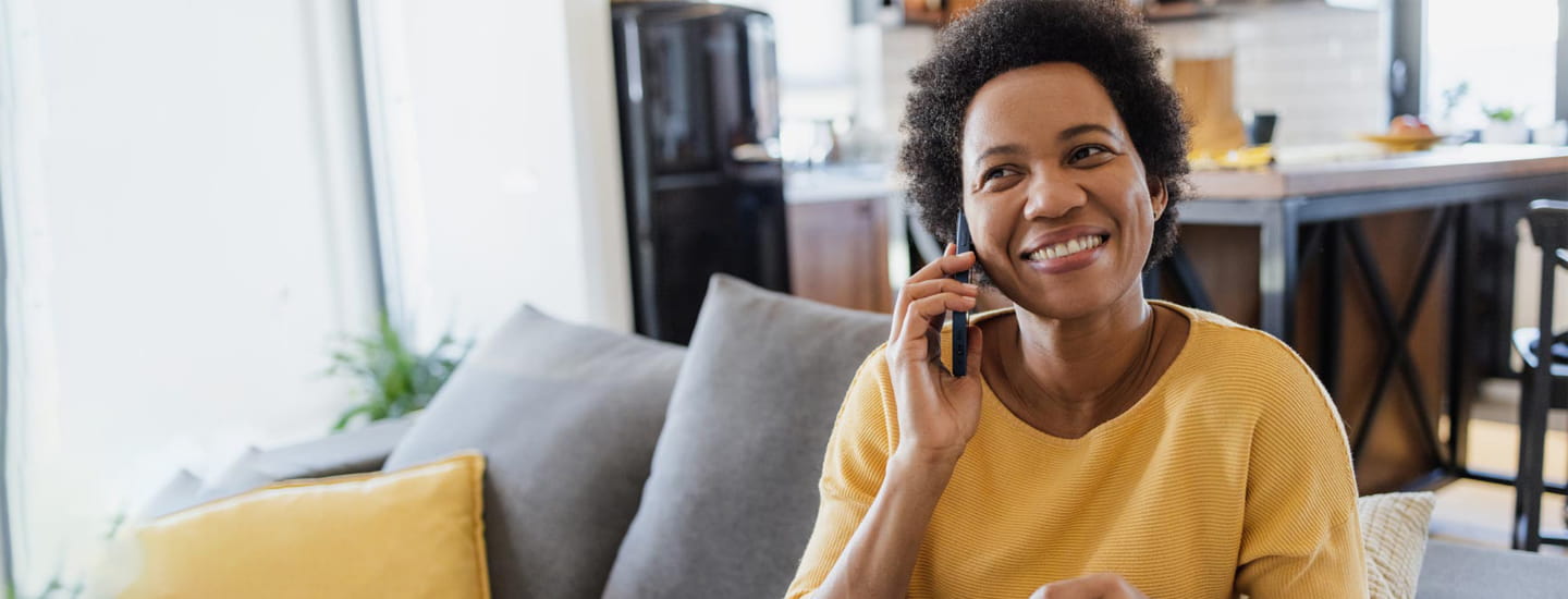 A woman sitting at home andon the phone