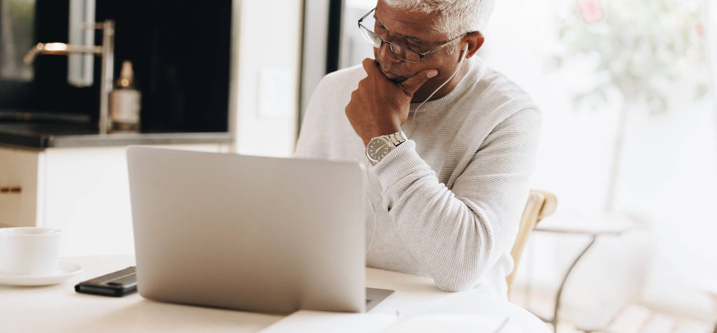 Mature businessman using a laptop while working from home.