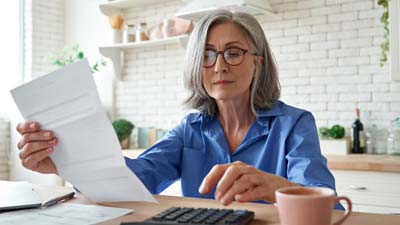 Woman in kitchen looking through paperwork