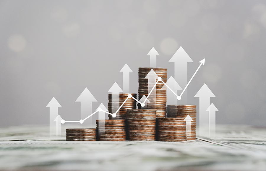 Different sized piles of coins with upward arrows and a line graph superimposed over them